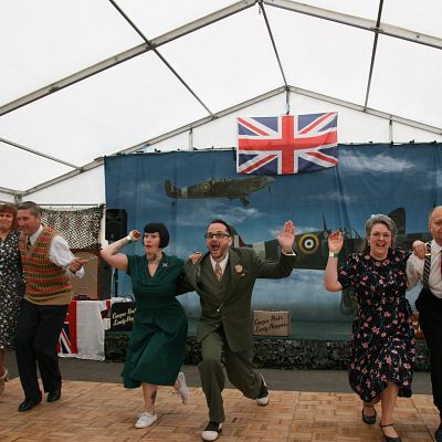 Cinque Ports Lindy Hoppers: Tenterden KESR 1940s Steam weekend May 2018 - Dapper Dru & Sugarfoot Sophie with the troop perfoming the 'Papas in bed' routine - Photo by Philip Lindhurst