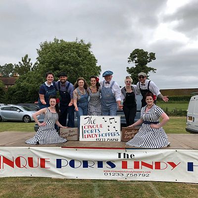 Cinque Ports Lindy Hoppers: Bodiam Senlac Classic Car show June 2018 - Posing on stage with the Victory Sisters at the Car Show for the Hastings Observer (with special guest Lucky Lucie whilst Sugarfoot Sophie recovered from a dancing injury) - Photo by Frank Copper
